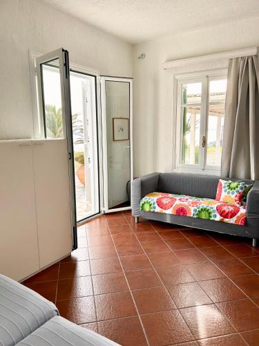 a living room with a couch and two windows at Fos Apartments Mykonos in Agios Ioannis Mykonos
