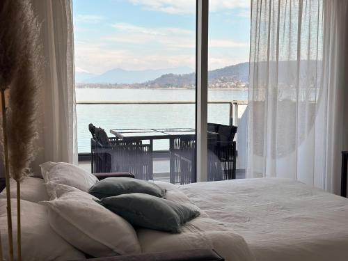 a bedroom with a bed and a view of the water at Aquavista Residence - Lake & Poolside Vacation Homes in Castelletto sopra Ticino