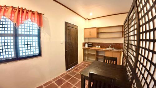 a dining room with a table and a kitchen at The Lighthouse Resort in Oslob