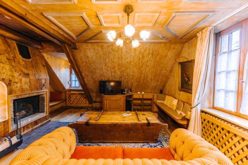 a living room with a couch and a fireplace at Les Violettes Hotel & Spa in Jungholtz