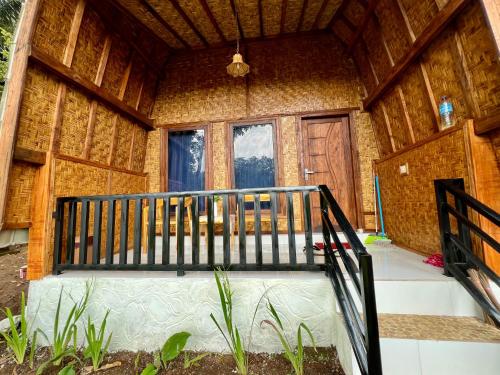 a porch of a house with a staircase in it at Azhani Bungalow in Tetebatu