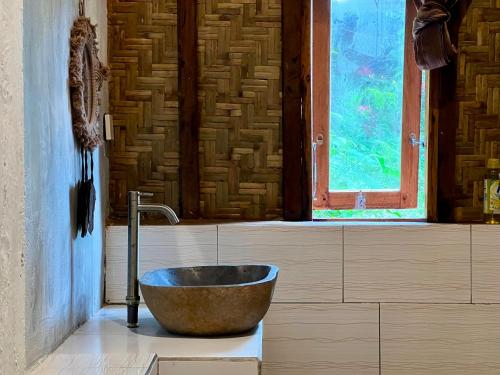 a bathroom with a bowl sink and a window at Azhani Bungalow in Tetebatu