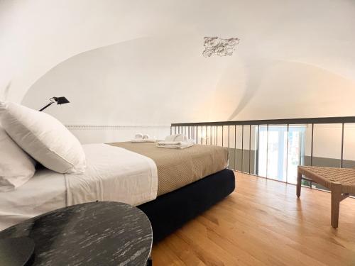 a bedroom with a bed and a table in it at Elena Suites - Boutique Apartments in Lecce