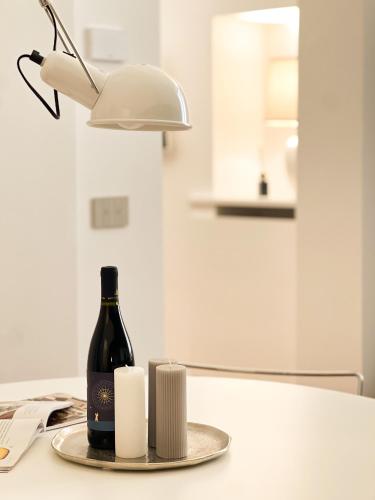 a bottle of wine and a lamp on a table at Elena Suites - Boutique Apartments in Lecce