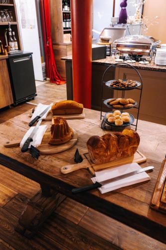 a table with different types of bread and pastries on it at Les Violettes Hotel & Spa in Jungholtz