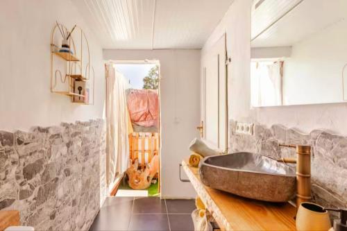 a bathroom with a sink and a stone wall at Flor de Loto Tantralove in Aguatona