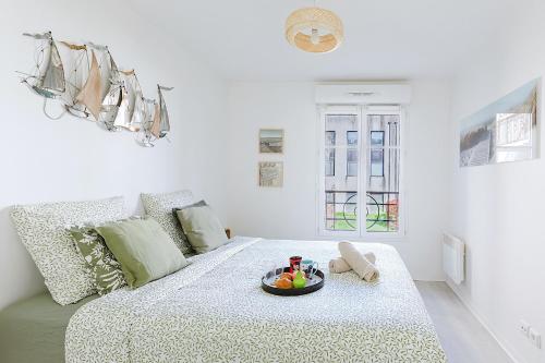Cette chambre blanche comprend un lit avec un bol de fruits. dans l'établissement L'Eden - City Center - DISNEY 8 min, PARIS 28 min - GARE 1 min - PARKING - Free WIFI, à Bussy-Saint-Georges