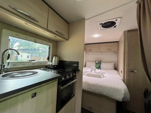 a kitchen with a sink and a bed in an rv at Ban Nokngang campsite in Ban Nok Ngang