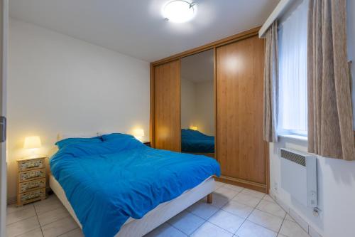 Un dormitorio con una gran cama azul y una ventana en Gilles 124, en Ostende