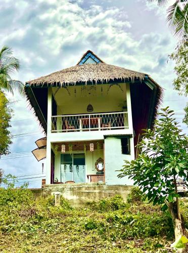 パンガン島にあるCozy Seaview Beach Studioの茅葺き屋根の白屋敷