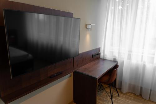 a large flat screen tv sitting on top of a desk at Cavallestro Deluxe in Kitzingen
