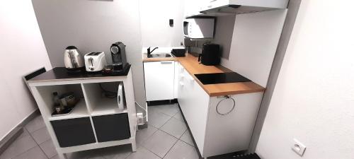 - une petite cuisine avec des placards blancs et un comptoir dans l'établissement Studio 721, Port Nature 7 au village naturiste, au Cap d'Agde