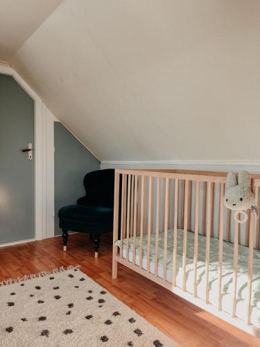a nursery with a crib and a chair at Charming house with wood stove near lake in Virserum
