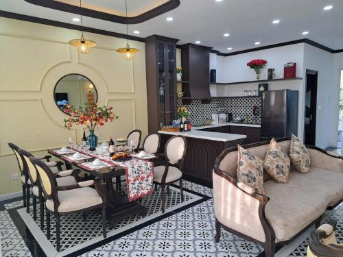 a dining room with a table and chairs and a kitchen at Phan Thiet Beach Villa in Bình Tú