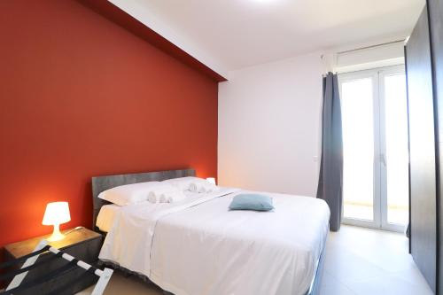 una camera da letto con un letto con una parete arancione di Dimora del Corso - L'Aquila a L'Aquila