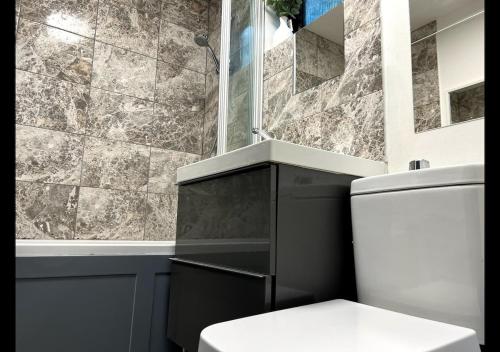 a bathroom with a toilet and a glass shower at London 2 bed-Apartment BEAUTIFUL in Borehamwood