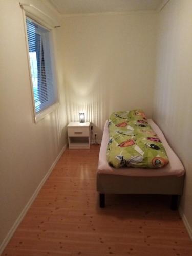 a small bedroom with a bed and a window at Sandeidfjorden overnatting in Sandeid