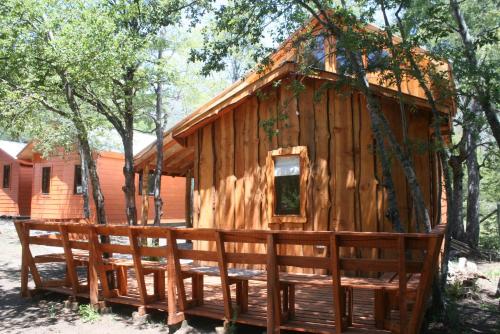 a wooden cabin with a fence in front of it at Cabañas Tronco Mayen in Las Trancas