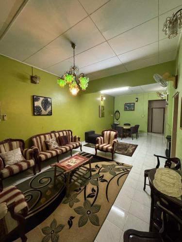 a living room with a couch and chairs and a table at Tokku's House Stadium Gong Badak Drawbridge Umt Unisza Mydin Gong Badak Airport Lapangan Terbang Sultan Mahmud Pantai Miami in Kampong Balai Maras