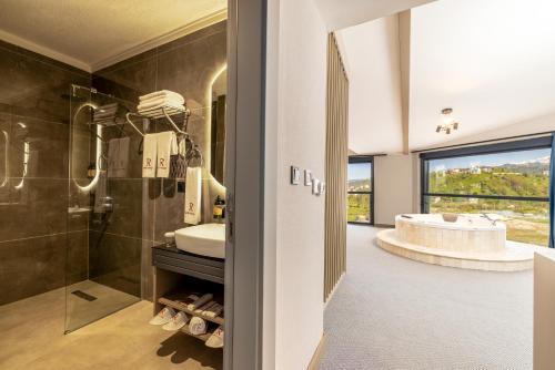 PazarにあるRossi Luxury Hotelのシャワー、洗面台、浴槽を備えたバスルーム