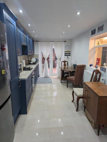 a kitchen with blue cabinets and a dining room at The Liddington in London