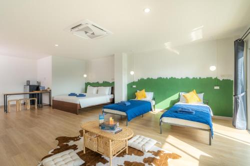 a large room with two beds and a table at De Blue Door, Hatyai in Hat Yai