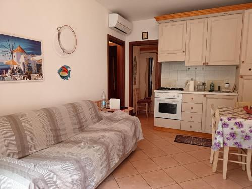 a living room with a couch and a kitchen at REX LO SCOGLIETTO Nuova Gestione in Punta Ala