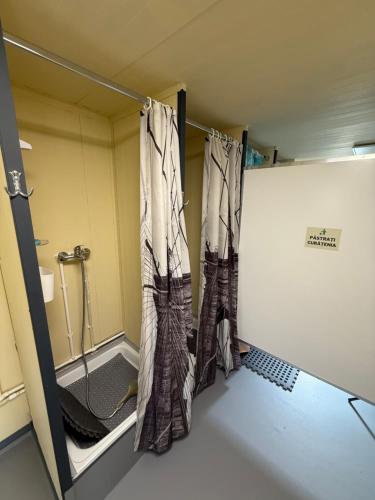 a bathroom with curtains hanging in a room at Green Camping in Gălăoaia