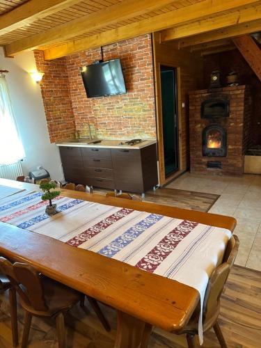 a dining room with a table and a fireplace at Pensiunea Ionela in Zemeş