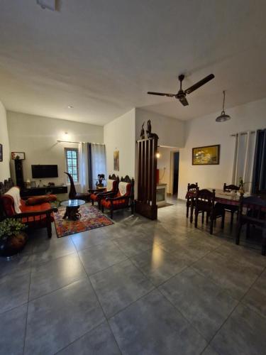 a living room filled with furniture and a ceiling fan at Parthees Homestay in Meppādi