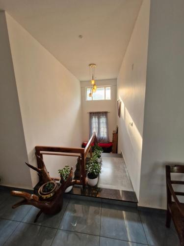 a room with a staircase with a chair and a window at Parthees Homestay in Meppādi