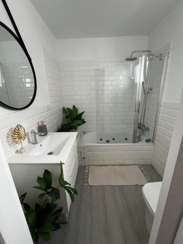 a white bathroom with a sink and a shower at Menorca Palm Villa in Cala en Blanes