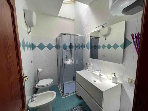 a bathroom with a toilet and a sink and a shower at Casetta Storica Sotto Torre in Calasetta