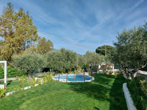 a garden with a swimming pool and trees at Casa Lachesi in Caccamo
