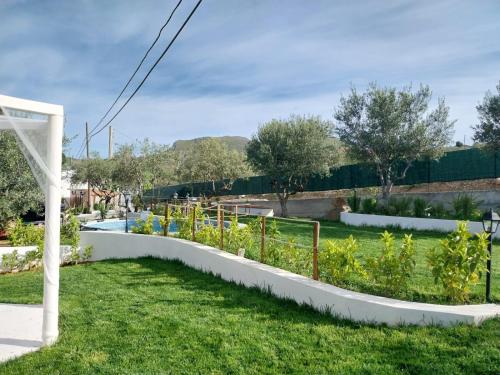 a garden with flowers and a white fence at Casa Lachesi in Caccamo