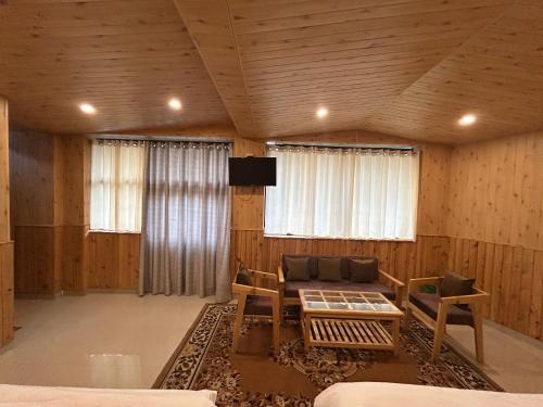 a living room with a couch and a tv at Hotel Ganpati in Lohaghāt