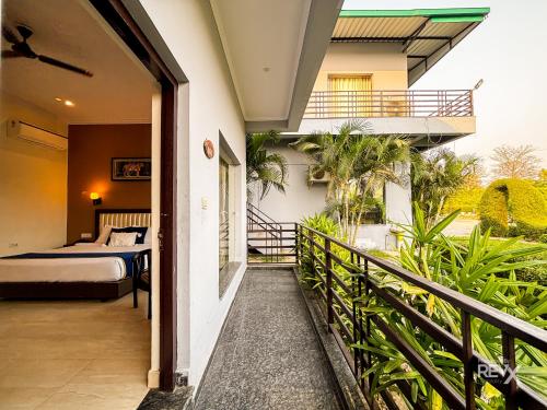 einem Balkon eines Hauses mit einem Bett und einem Schlafzimmer in der Unterkunft The Corbett Grace Resort in Rāmnagar