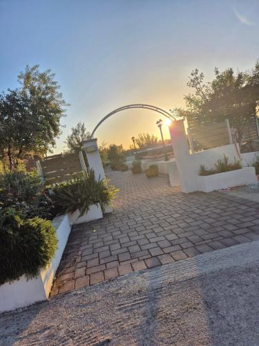 a brick walkway with an arch in a park at tzogias apartments nonna studio in Lassi