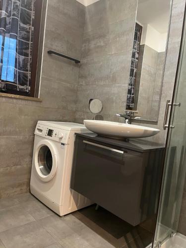 a bathroom with a washing machine and a sink at GreenForum in Assago