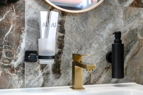 a bathroom sink with a faucet and a mirror at AH - Duomo Signature in Milan