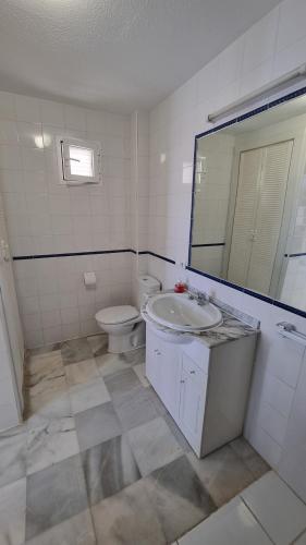 ein Badezimmer mit Toilette, Waschbecken und Spiegel in der Unterkunft Vera Natura isleta nudista in Vera