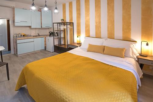 a bedroom with a large yellow bed and a kitchen at Giardino Giusti House & Court in Verona