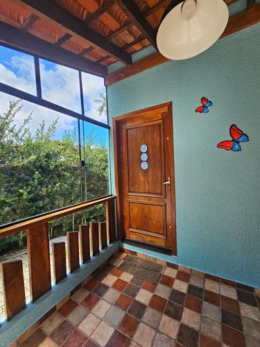 a room with a door and butterflies on the wall at Casa Cica in Ubatuba