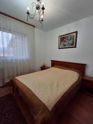 a bedroom with a bed and a chandelier at Pensiunea TOTAL Ceahlau in Ceahlău