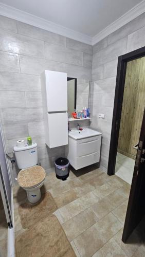 a bathroom with a toilet and a sink and a mirror at Appartement Nador in Nador