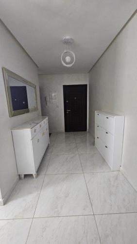an empty room with a large white room with a black door at Appartement Nador in Nador