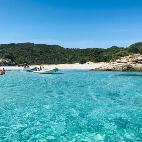 deux bateaux dans l'eau à côté d'une plage dans l'établissement T2 Farinole, vue mer sur le golfe de St Florent, plage a pied, à Farinole