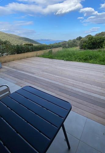 un banc installé au-dessus d'une terrasse en bois dans l'établissement T2 Farinole, vue mer sur le golfe de St Florent, plage a pied, à Farinole