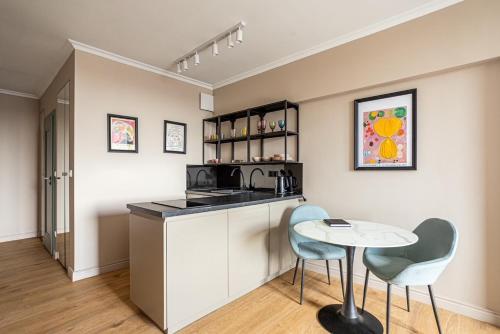 a kitchen with a counter and a table and chairs at Triton Park Apartments in Warsaw