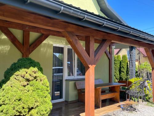 a wooden pergola with a bench on a patio at Dom pod orzechem in Spytkowice
